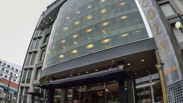 A hotel with a modern glass facade and a prominent sign.
