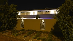 Een gebouw met een plat dak, rechthoekige ramen en een verhard pad.