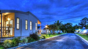 Uma casa térrea com varanda, um pequeno deck e interior bem iluminado.