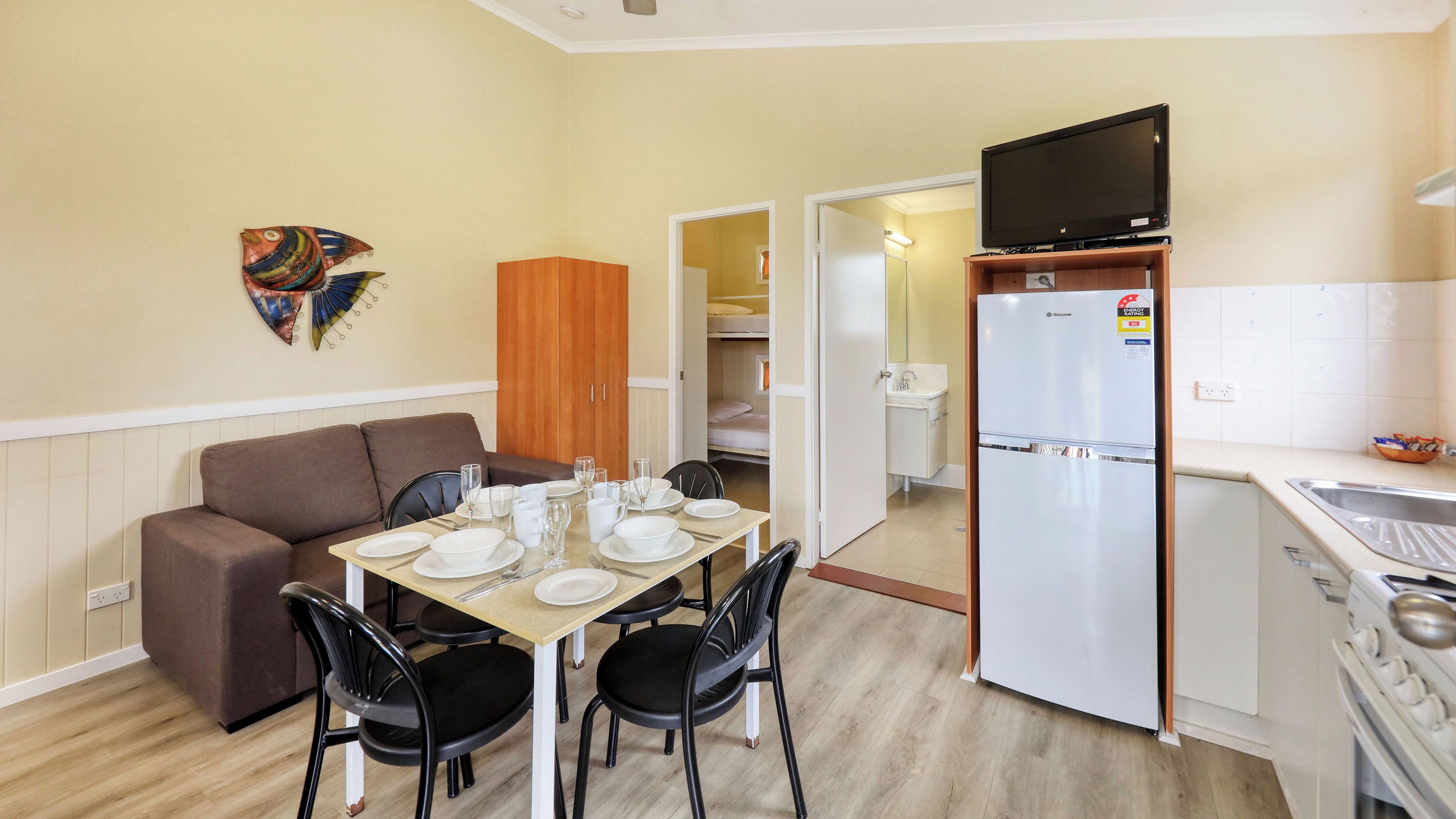 A compact kitchenette with a refrigerator, a sink, and a stove.