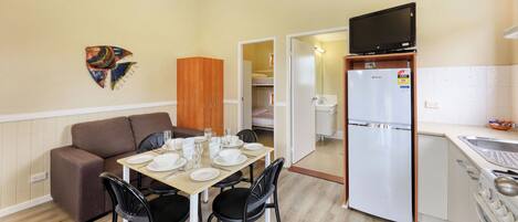 A compact kitchenette with a refrigerator, a sink, and a stove.