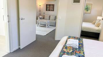 A hotel room with a bed, a small table, a sofa, and a mirror.