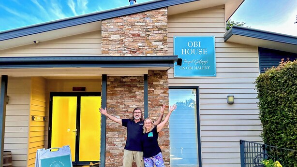 Un edificio con un cartel que dice "OBI HOUSE" y otro cartel para "YOGA @ OBI HOUSE".