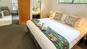 Un dormitorio con una cama grande, una puerta de madera, una ventana y un espejo.