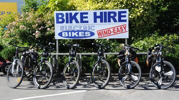 Sinalização para aluguel de bicicletas, incluindo elétricas e movidas a energia eólica.