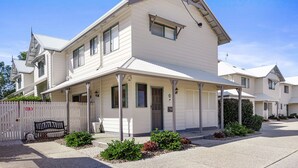 A white two-story house with a porch, a small garden, and a 'No Parking' sign. - Terrapin Apartments (Noosaville)