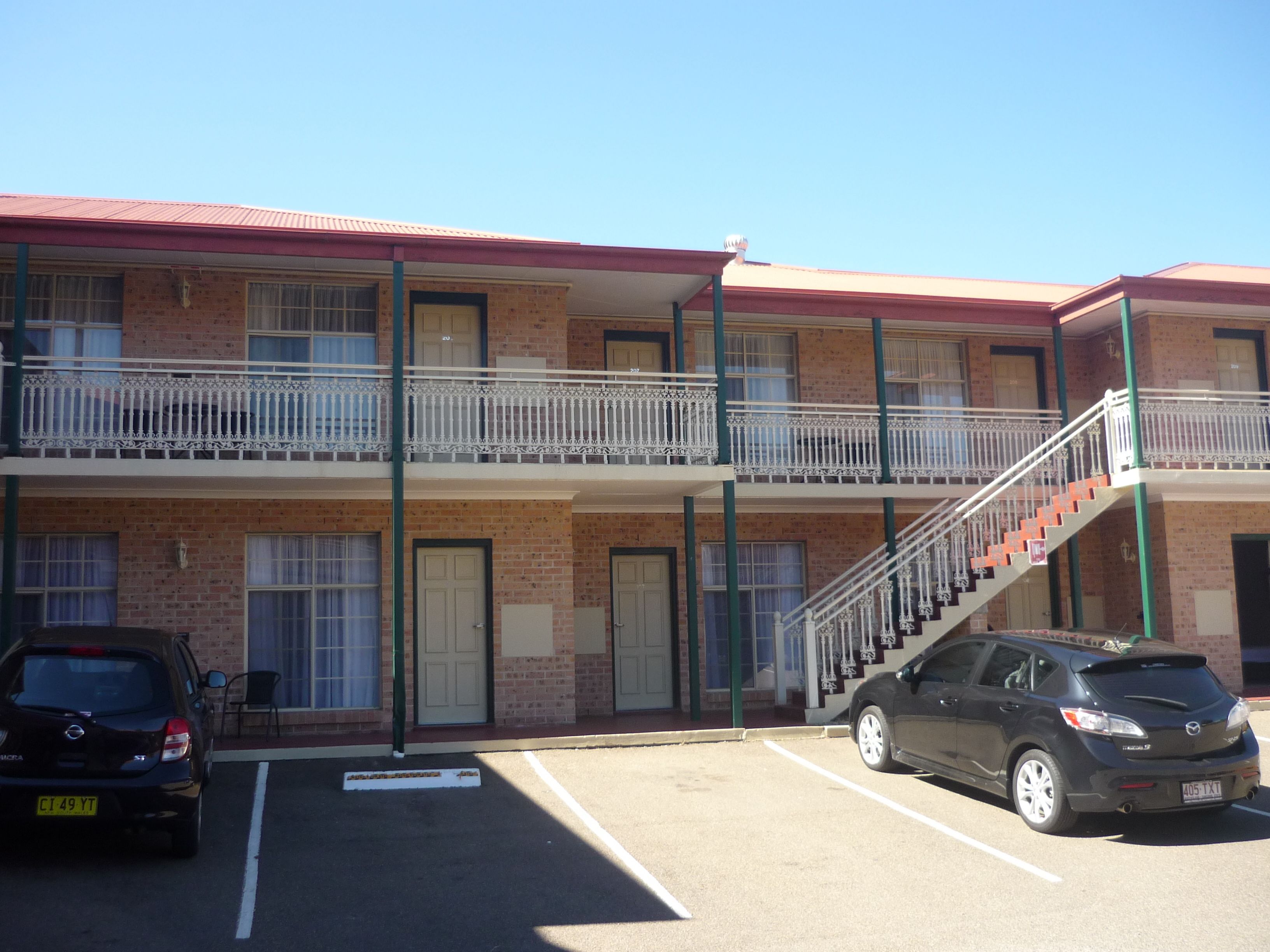 A two-story motel with a parking lot.