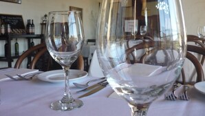 A dining table with wine glasses and cutlery, a chalkboard menu, and a framed picture on the wall. - Heritage Motor Inn Goulburn (Goulburn)