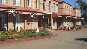 A historic building with arched windows and a red roof, featuring a sign for 'Goolburn Heritage'. - Heritage Motor Inn Goulburn (Goulburn)