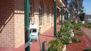 A brick building with a covered walkway and green columns. - Heritage Motor Inn Goulburn (Goulburn)