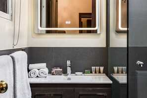 Un baño moderno con un espejo grande, un lavabo y artículos de aseo.