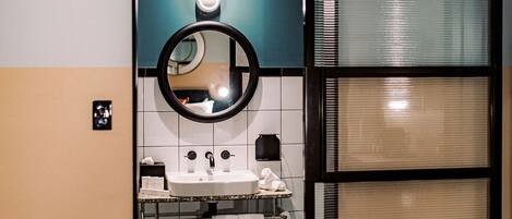 A bathroom with a sink, mirror, and towel rack.