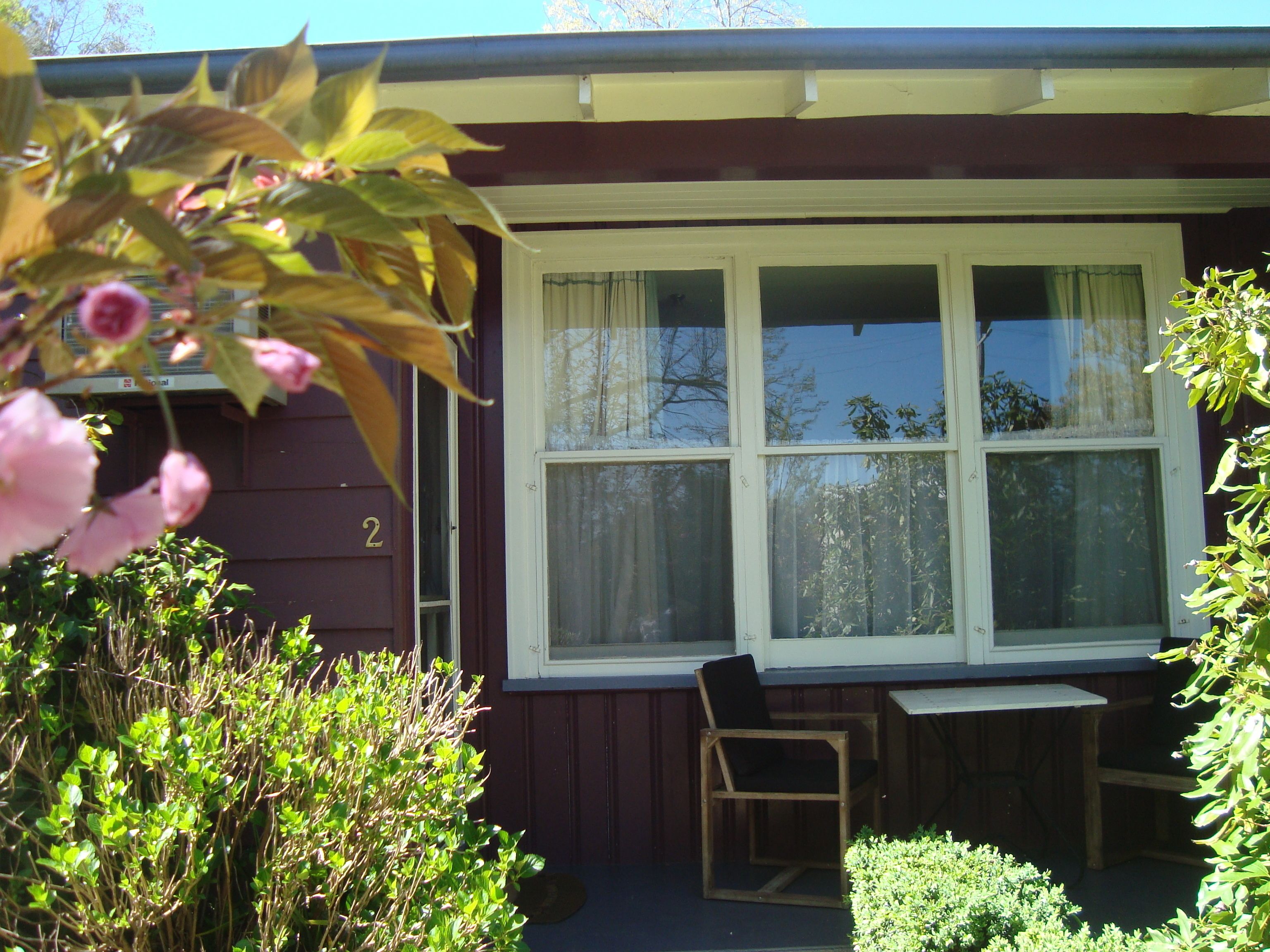 A house with a porch, a wooden chair, and a small table.