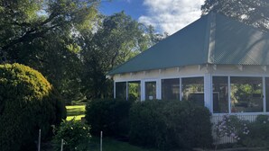 A building with a green roof, surrounded by well-maintained lawns and trees. - Emu Point Motel & Apartments (Emu Point)