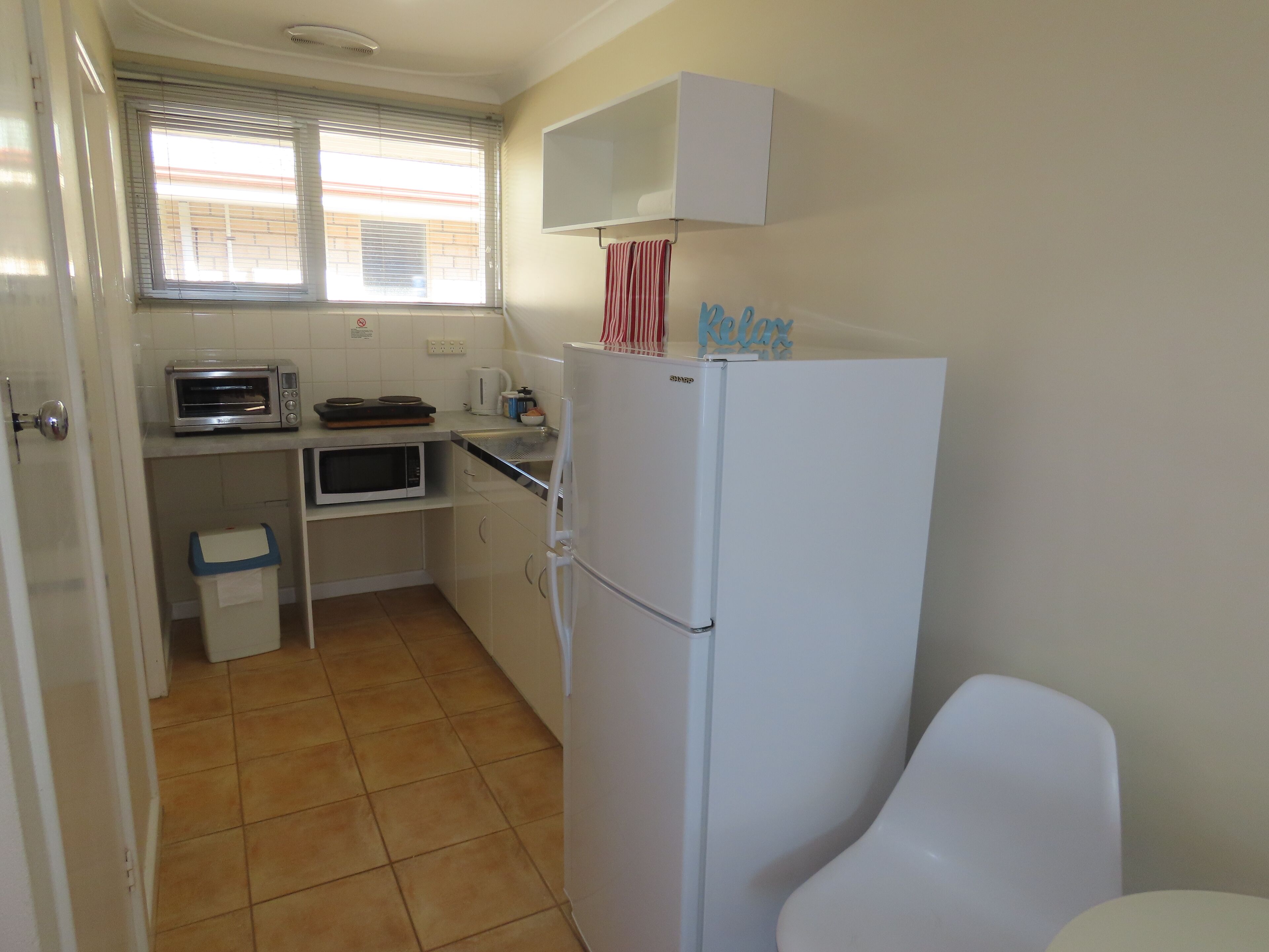 Una cocina compacta equipada con refrigerador, microondas y horno tostador.