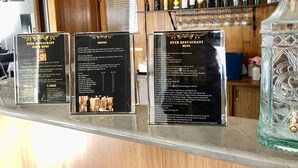 A restaurant counter with three menu boards displaying various food and drink options. - Byer Fountain Motor Inn, Holbrook (Holbrook)