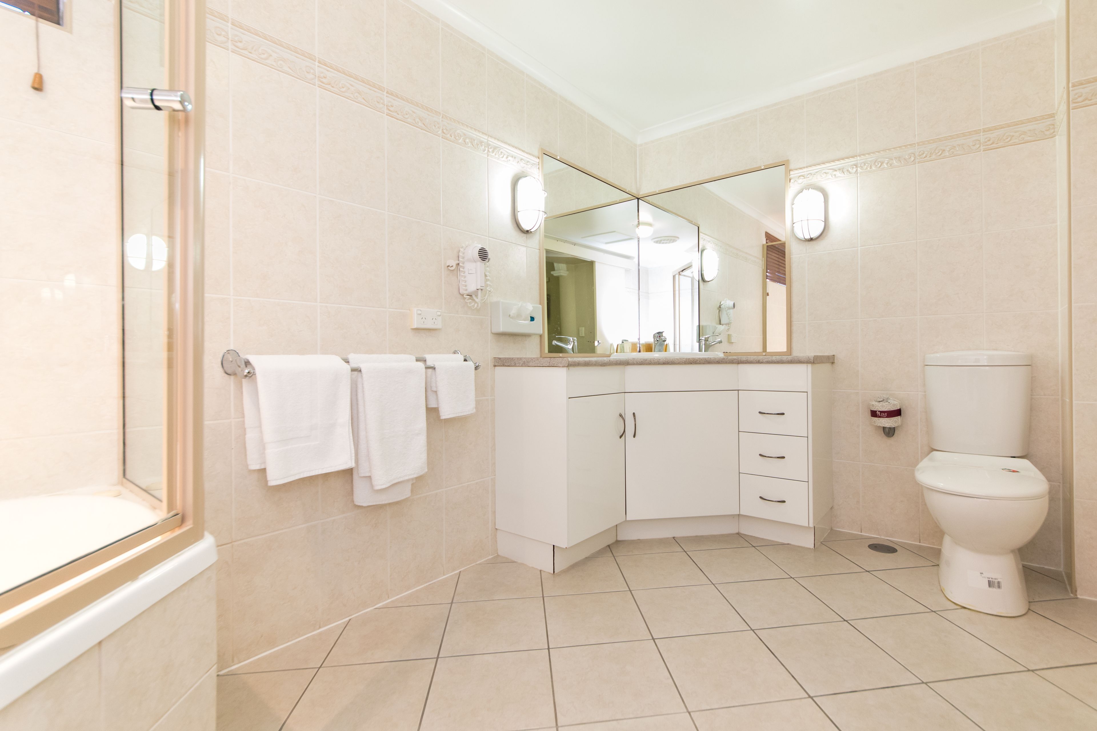 Un baño moderno con ducha, inodoro y tocador.