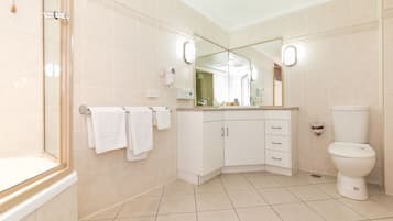 Un baño moderno con ducha, inodoro y tocador.