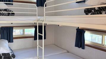 A bunk bed room with a window and curtains.