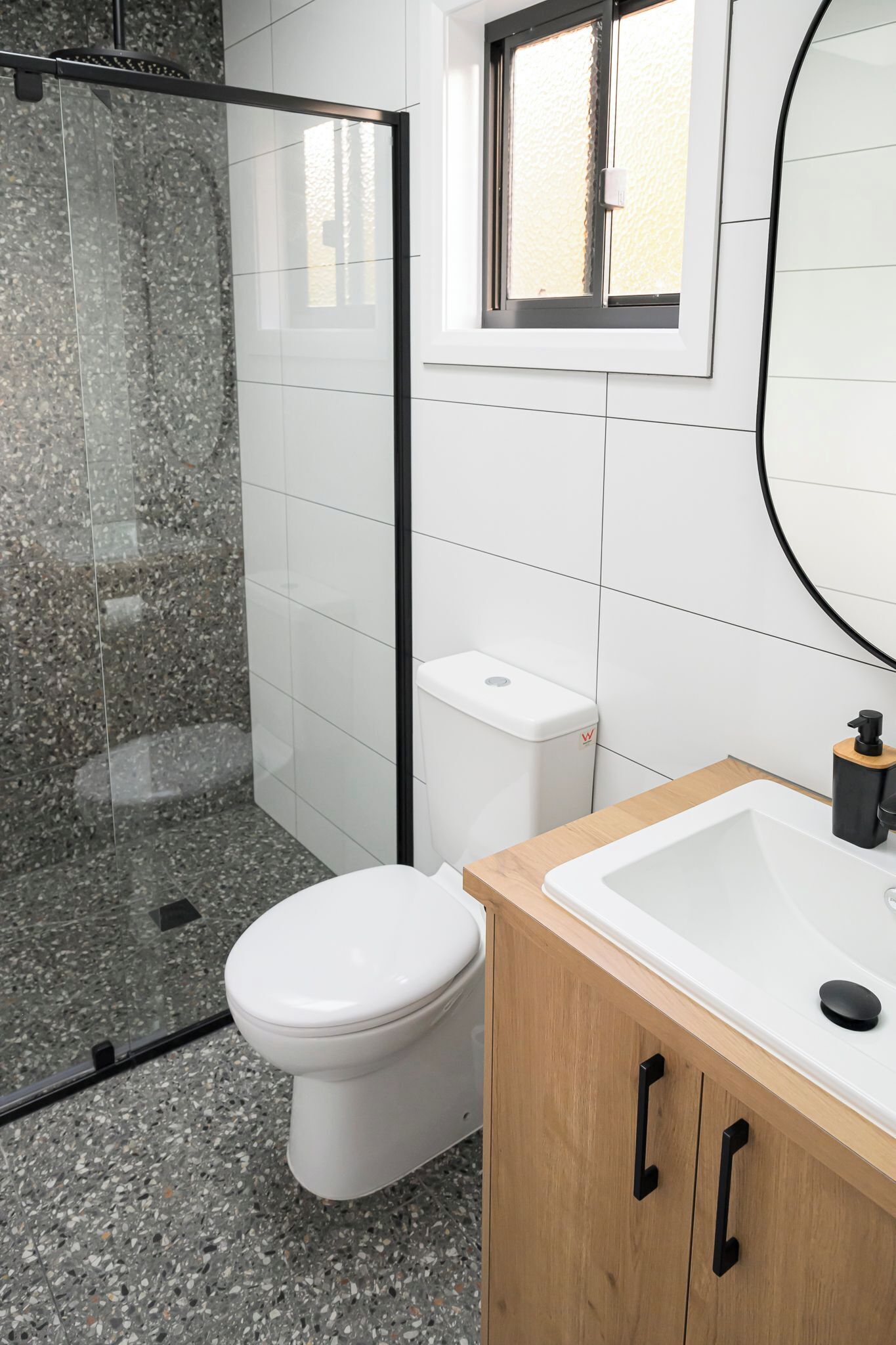 Un baño moderno con inodoro, ducha y lavamanos.