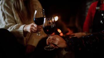 Due persone che sorseggiano vino in un ambiente scarsamente illuminato.