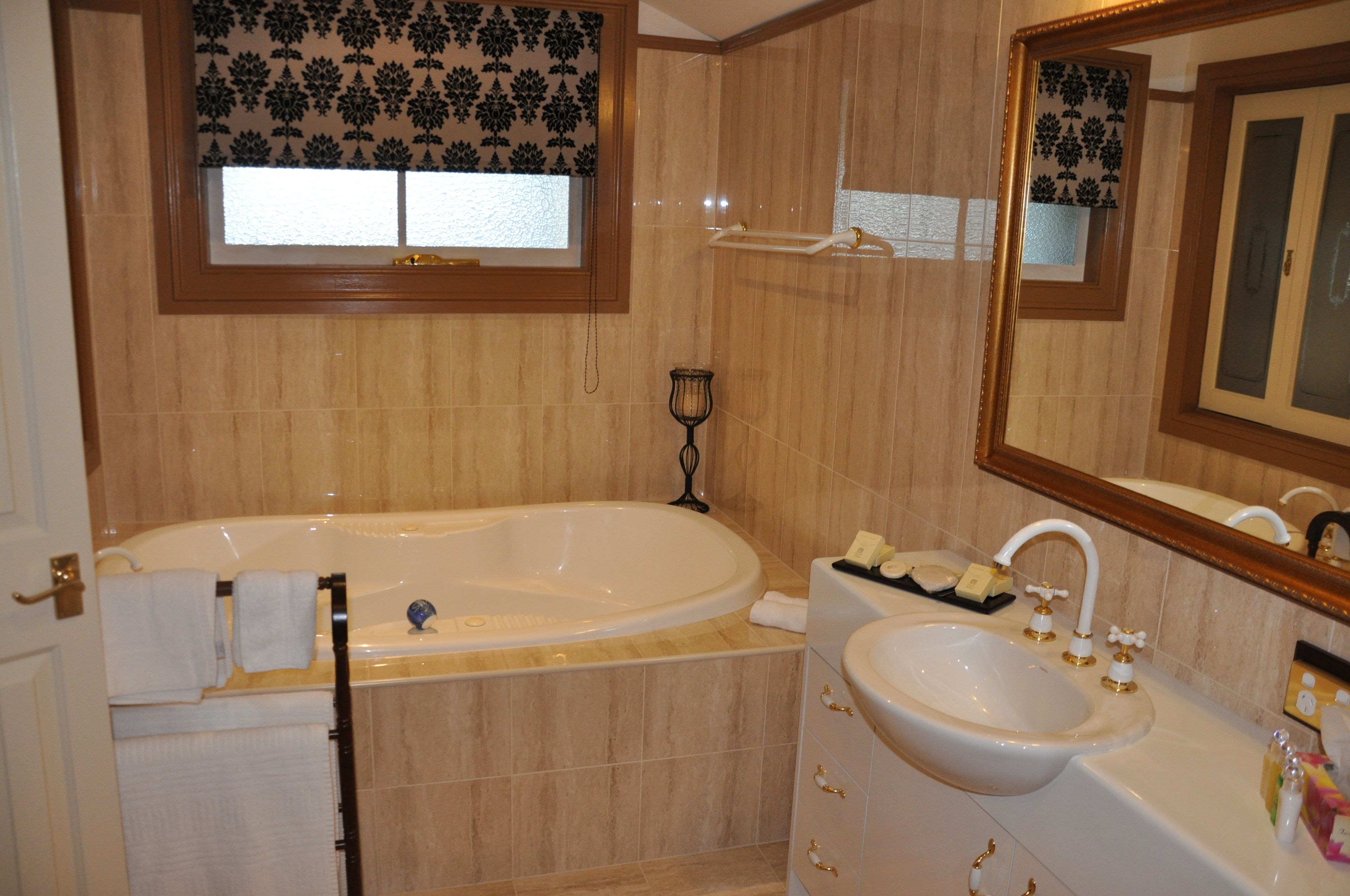 A bathroom with a bathtub, a sink, and a mirror.