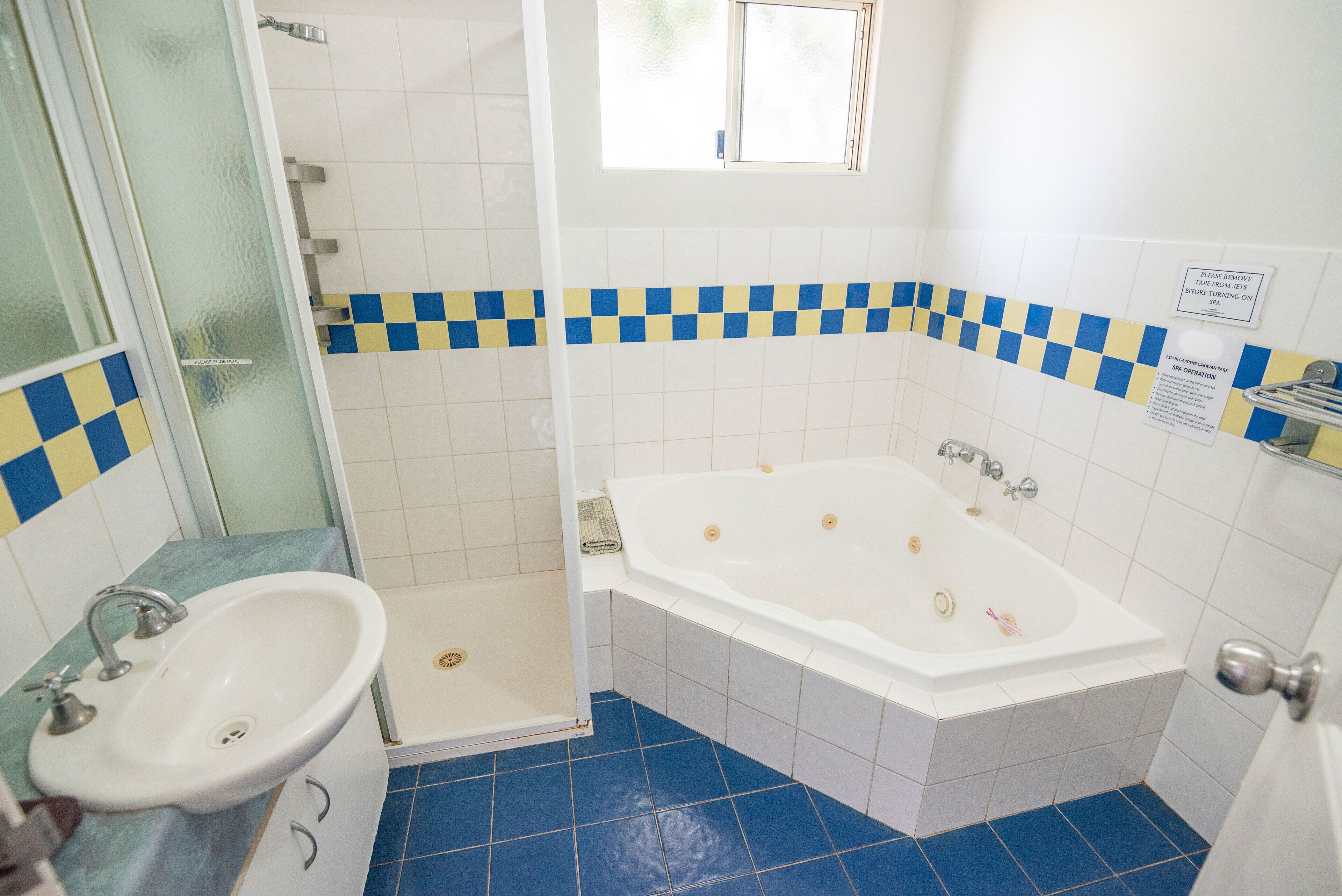 A bathroom with a white bathtub, a sink, and a shower.