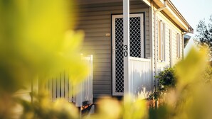 Une maison de plain-pied avec un porche, une porte moustiquaire et une boîte aux lettres.