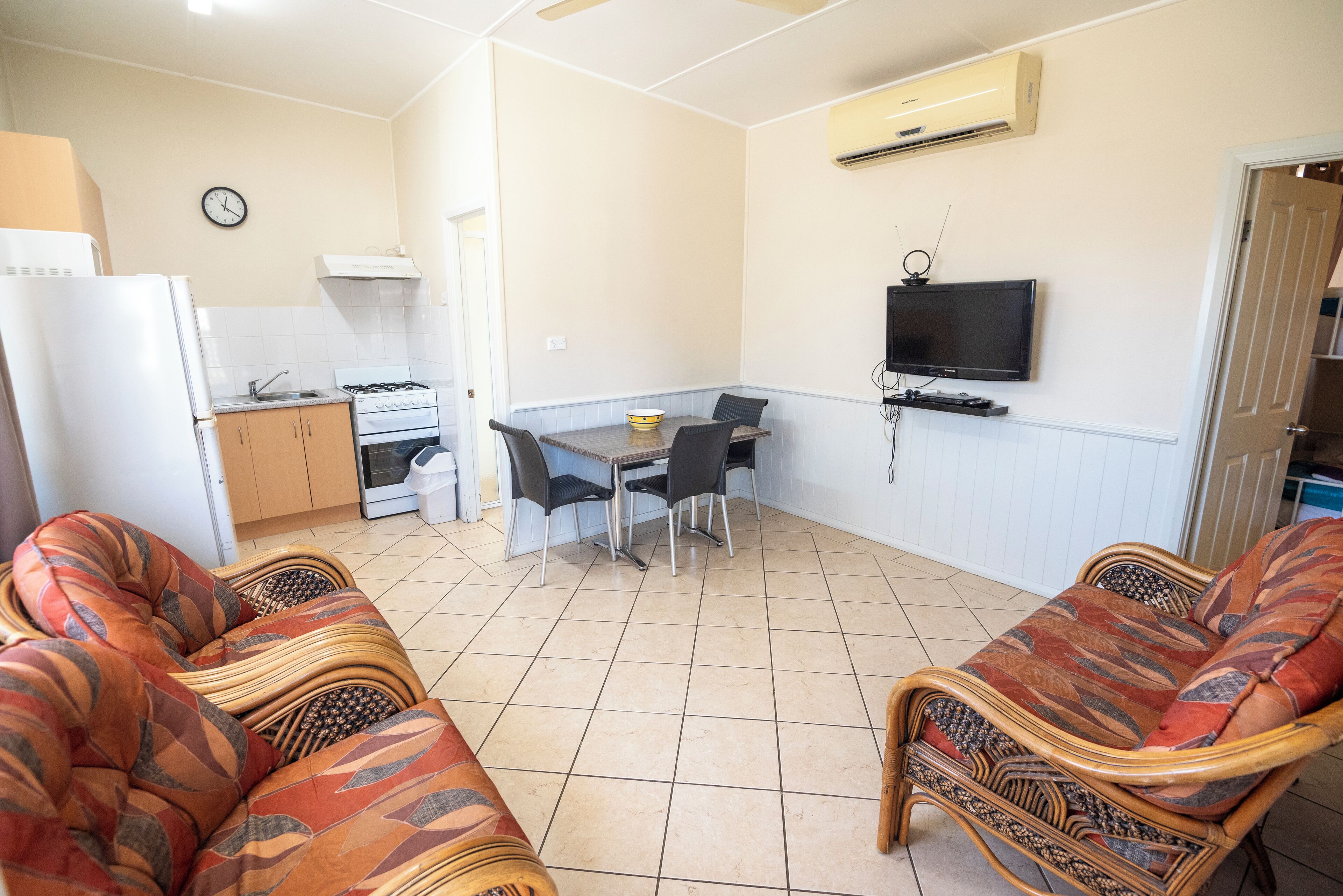 A compact living space with a kitchenette, dining area, and seating.