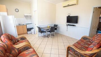 A compact living space with a kitchenette, dining area, and seating.