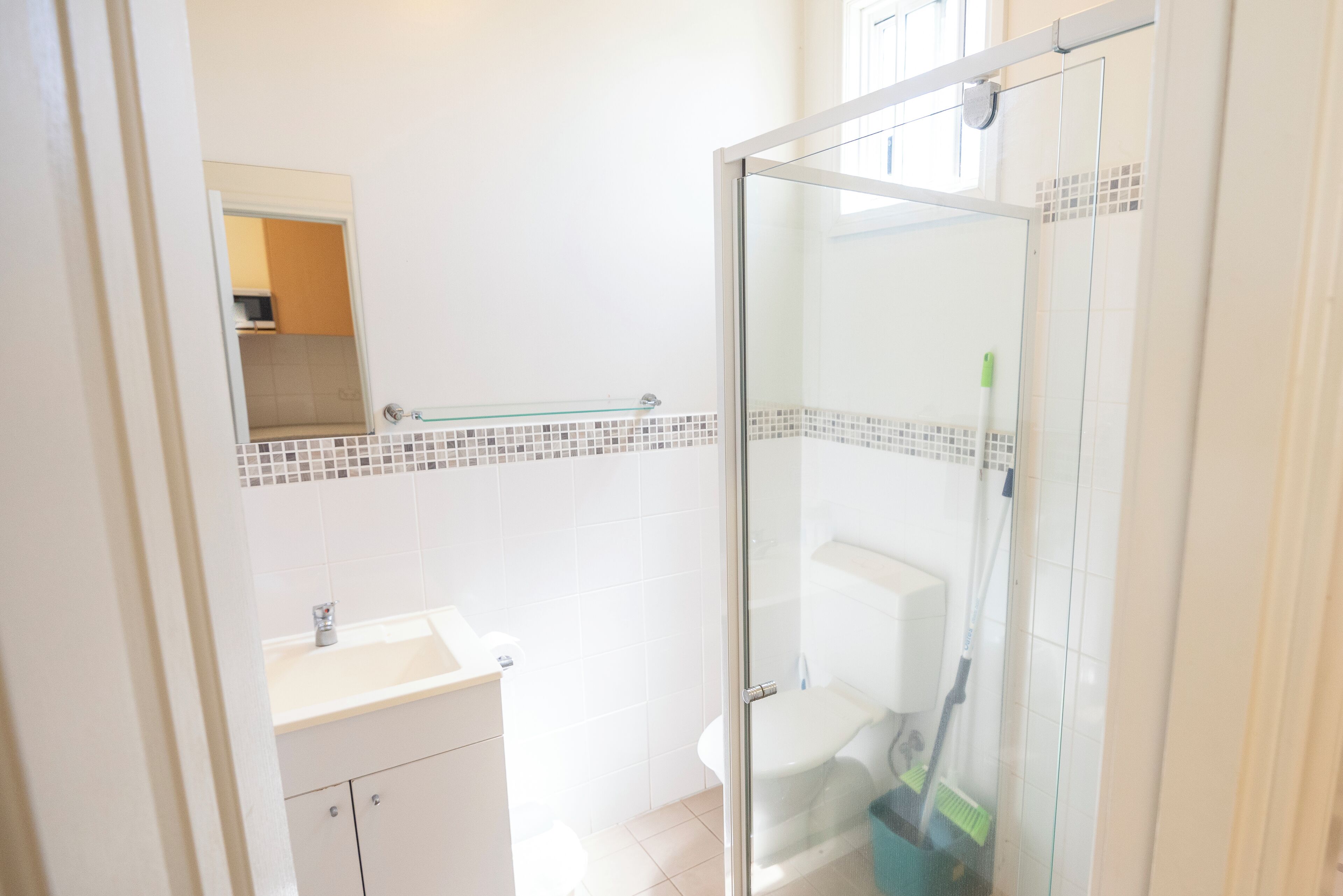 A bathroom with a glass shower enclosure, a sink, and a toilet.