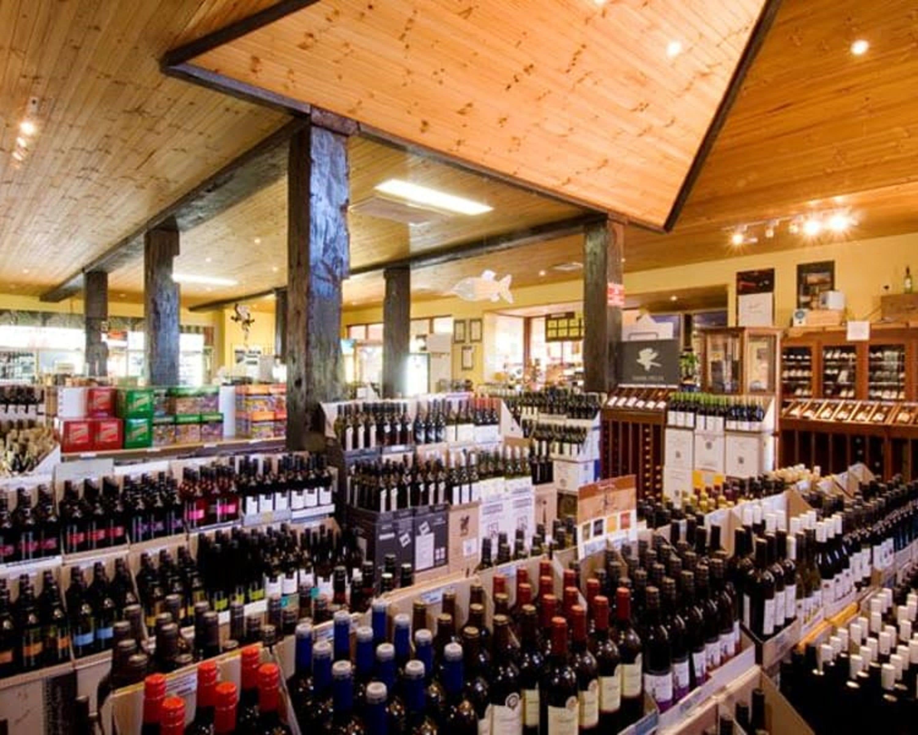 Een wijnwinkel met verschillende wijnflessen op de planken.