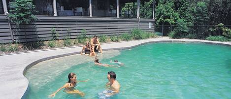 Una piscina al aire libre, sillones reclinables de piscina