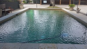 A rectangular pool with a tiled edge, surrounded by a low fence and potted plants. - Econo Lodge Chaparral Motel Ballina (West Ballina)