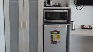 A kitchenette with a microwave, toaster, and refrigerator. - Econo Lodge Chaparral Motel Ballina (West Ballina)