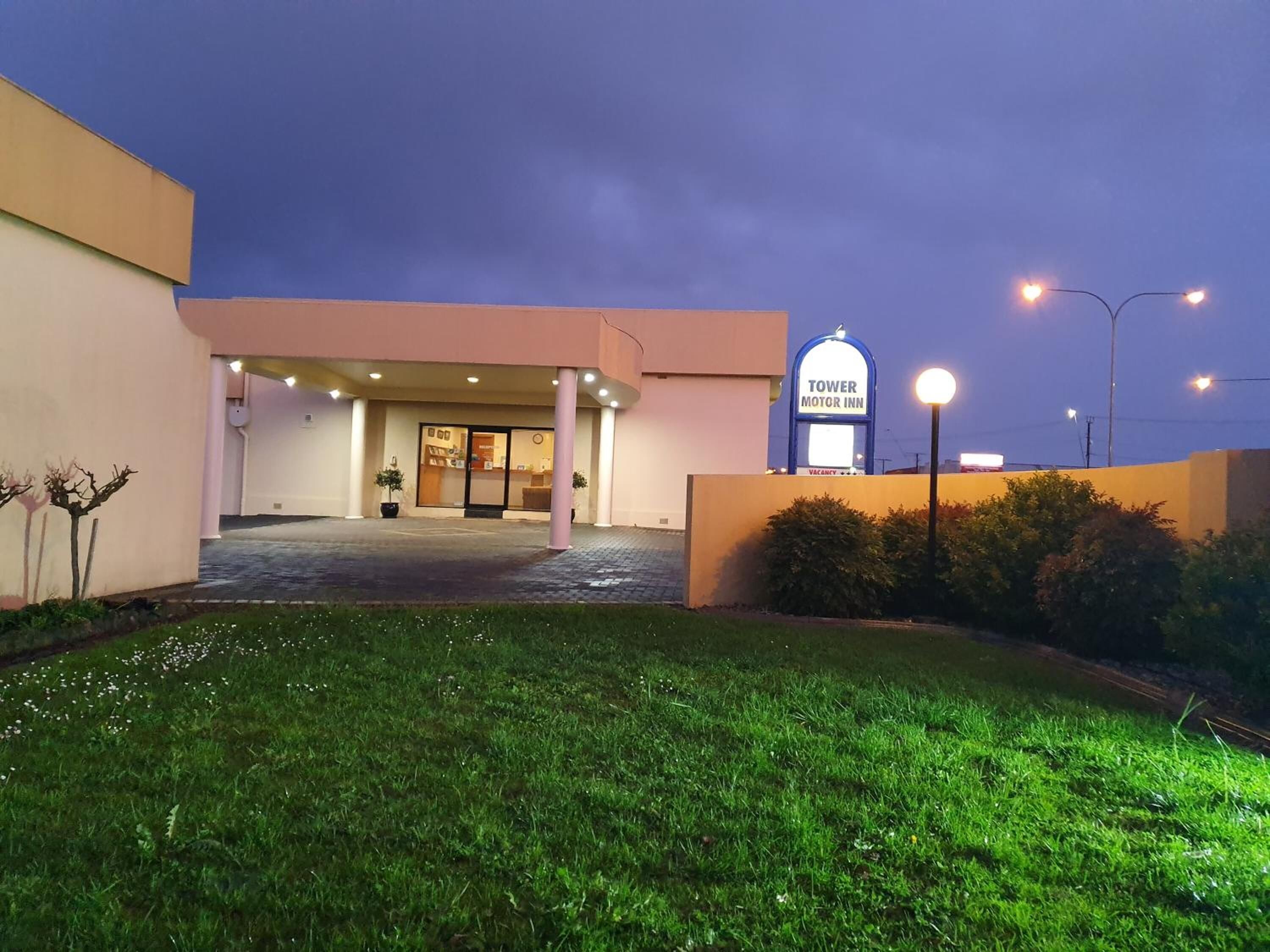 Entrada de un hotel con un letrero que dice 'TOWER MOTOR INN'.