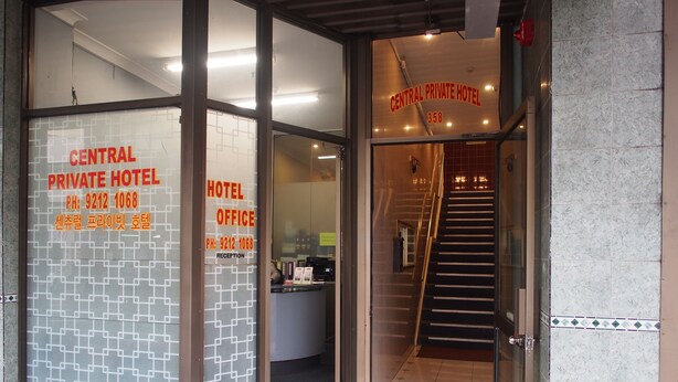 Der Eingang zum Central Private Hotel, mit einer Rezeption, einer Treppe und gut sichtbarer Beschilderung inklusive der Telefonnummer des Hotels.