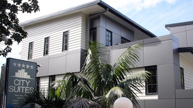 A modern building with a sign for "CITY SUITES" indicating a hotel. - City Suites Tauranga (Tauranga)