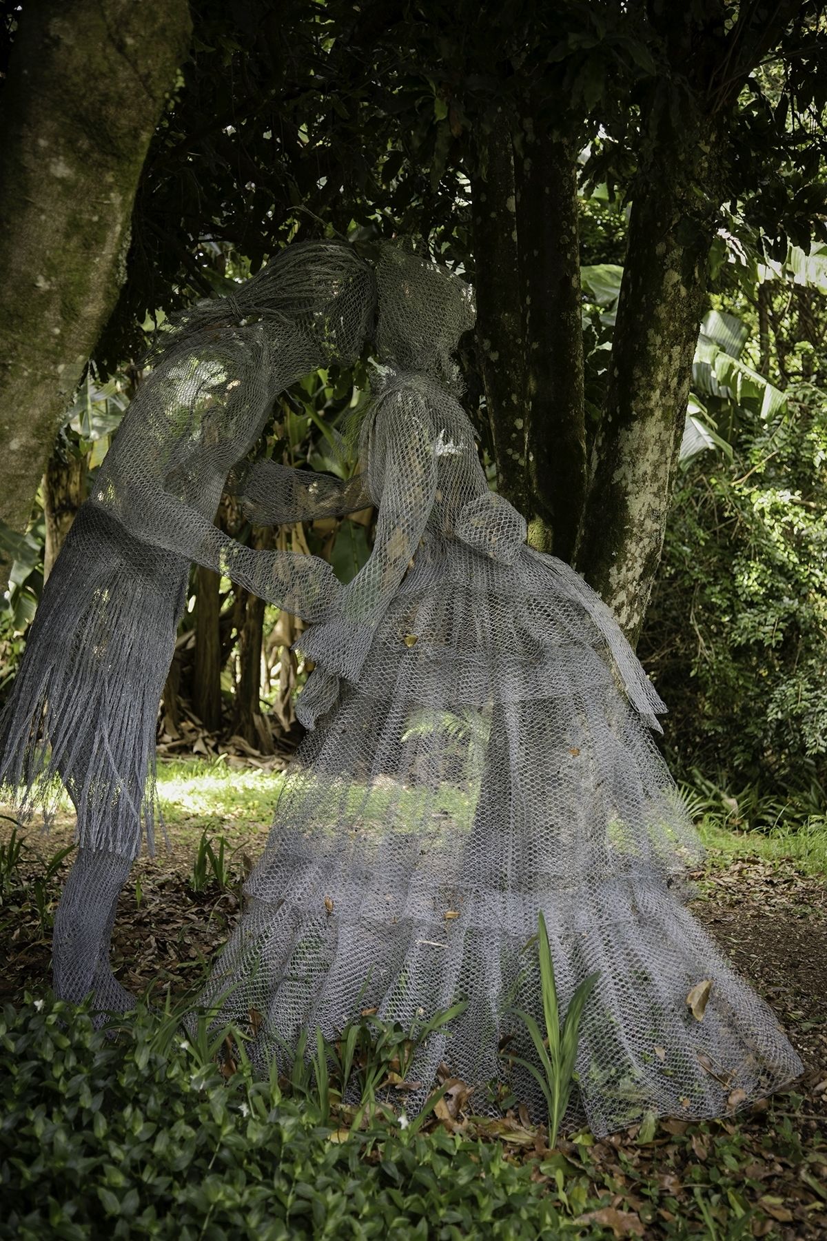 A sculpture of a woman in a forest setting.