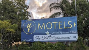 Letrero de motel con aviso de habitaciones disponibles e indicaciones hacia Restaurante Olive.