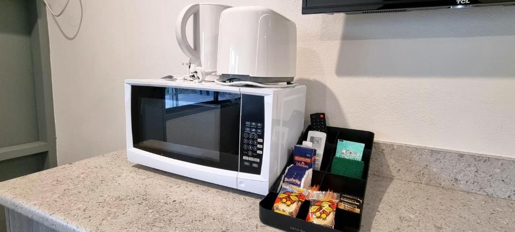 A microwave on a countertop with a tray of packaged food items.