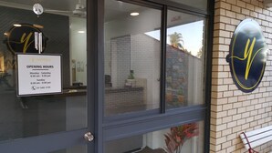 Exterior de un motel con un cartel de 'No Fumar', un cartel de 'MOTELS' y un cartel de 'HORARIO DE APERTURA'.