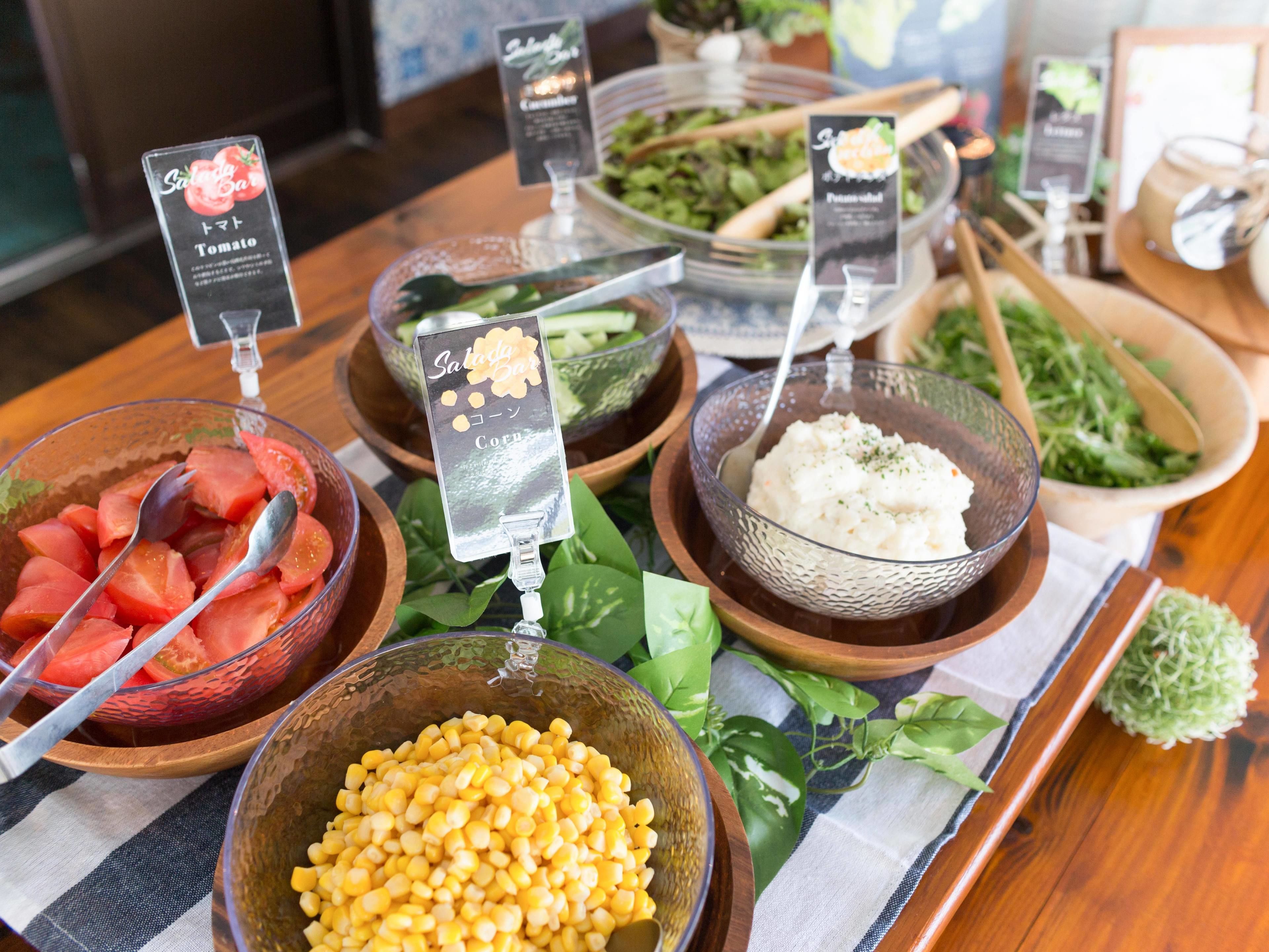 A buffet table with various food items and serving utensils.