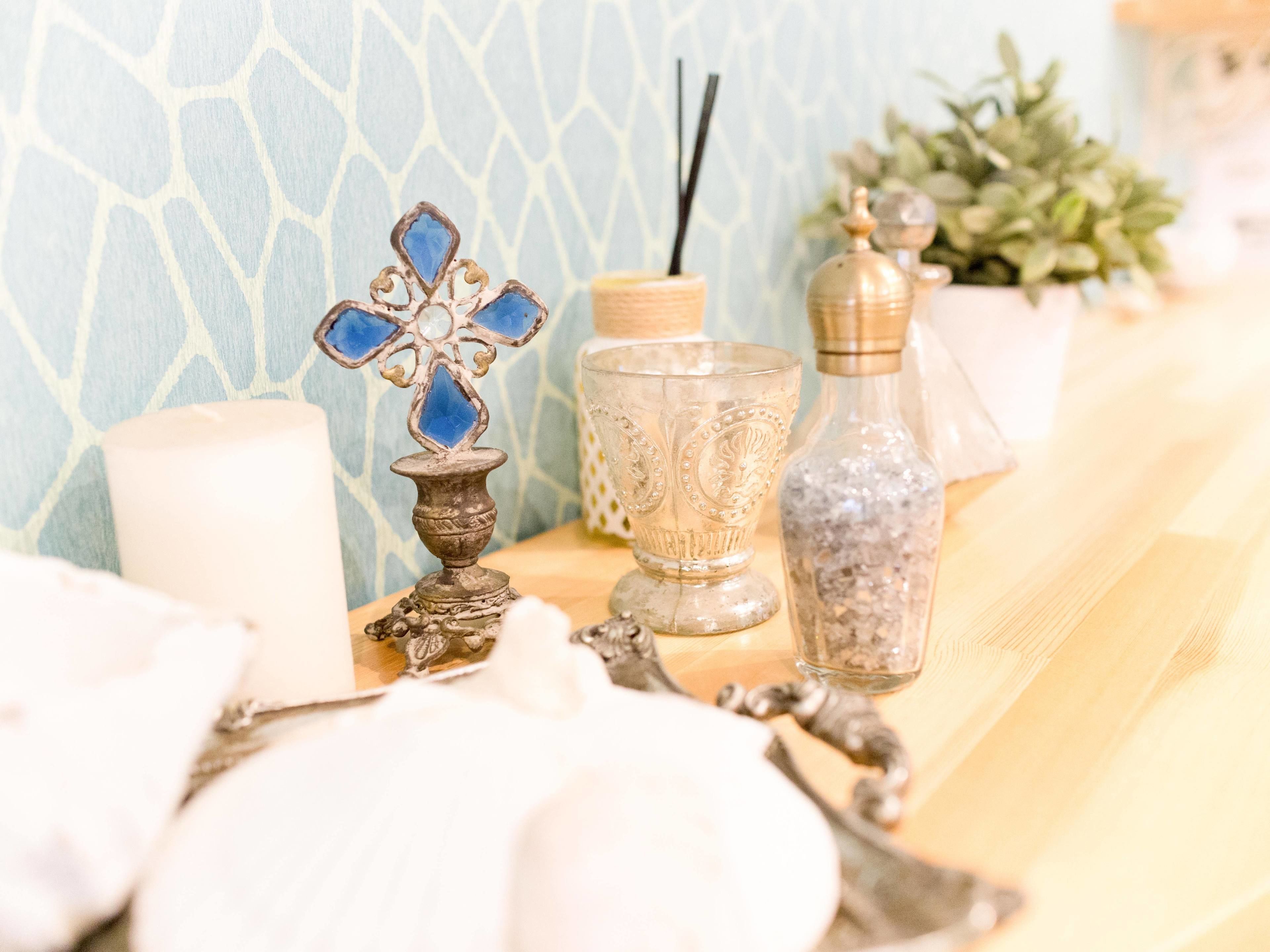 Une table ornée de divers objets décoratifs, notamment une bougie, un récipient en verre et une bouteille.
