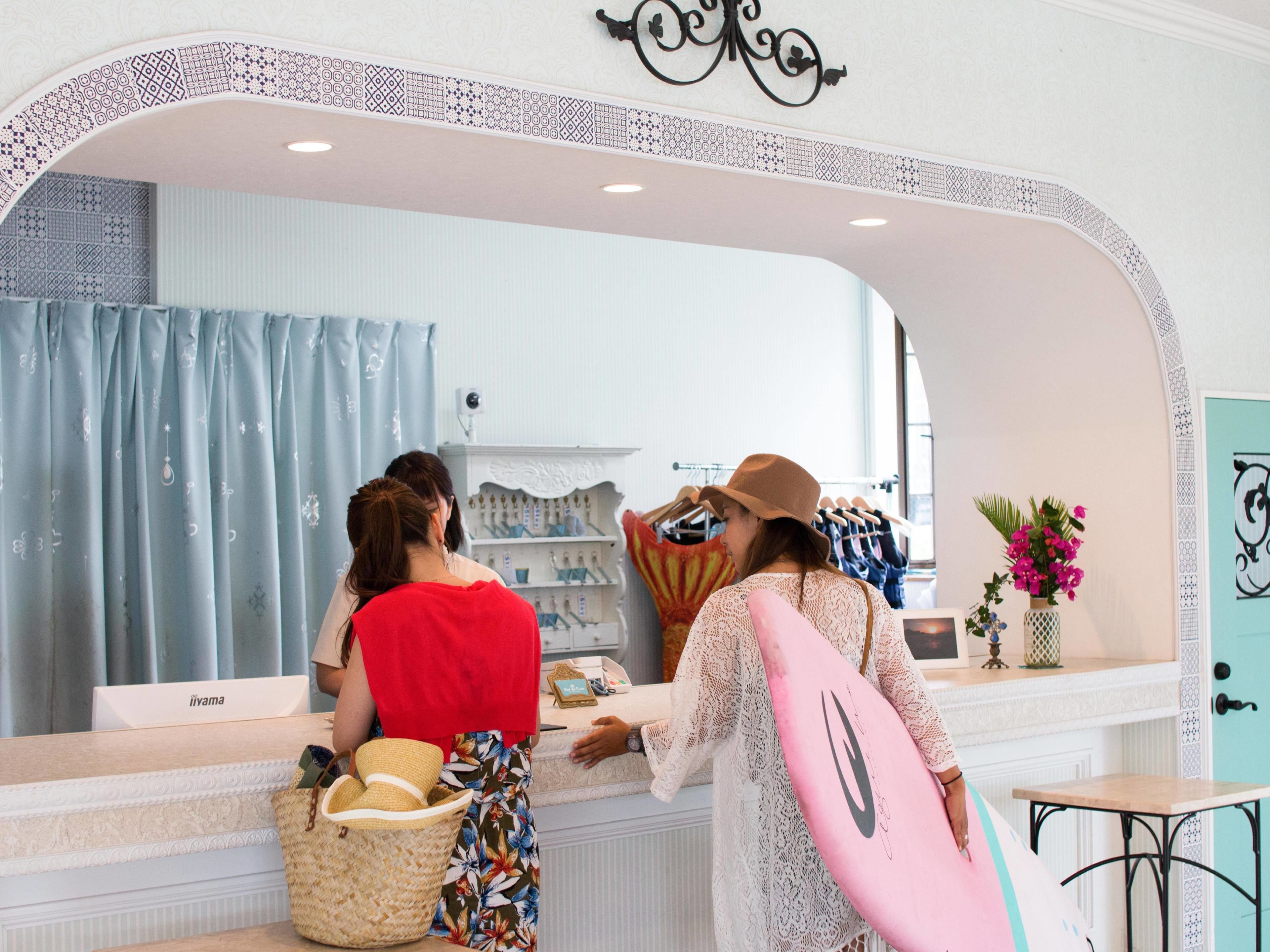 Una encimera con un arco decorativo, un espejo y una exhibición de sombreros y bolsos.