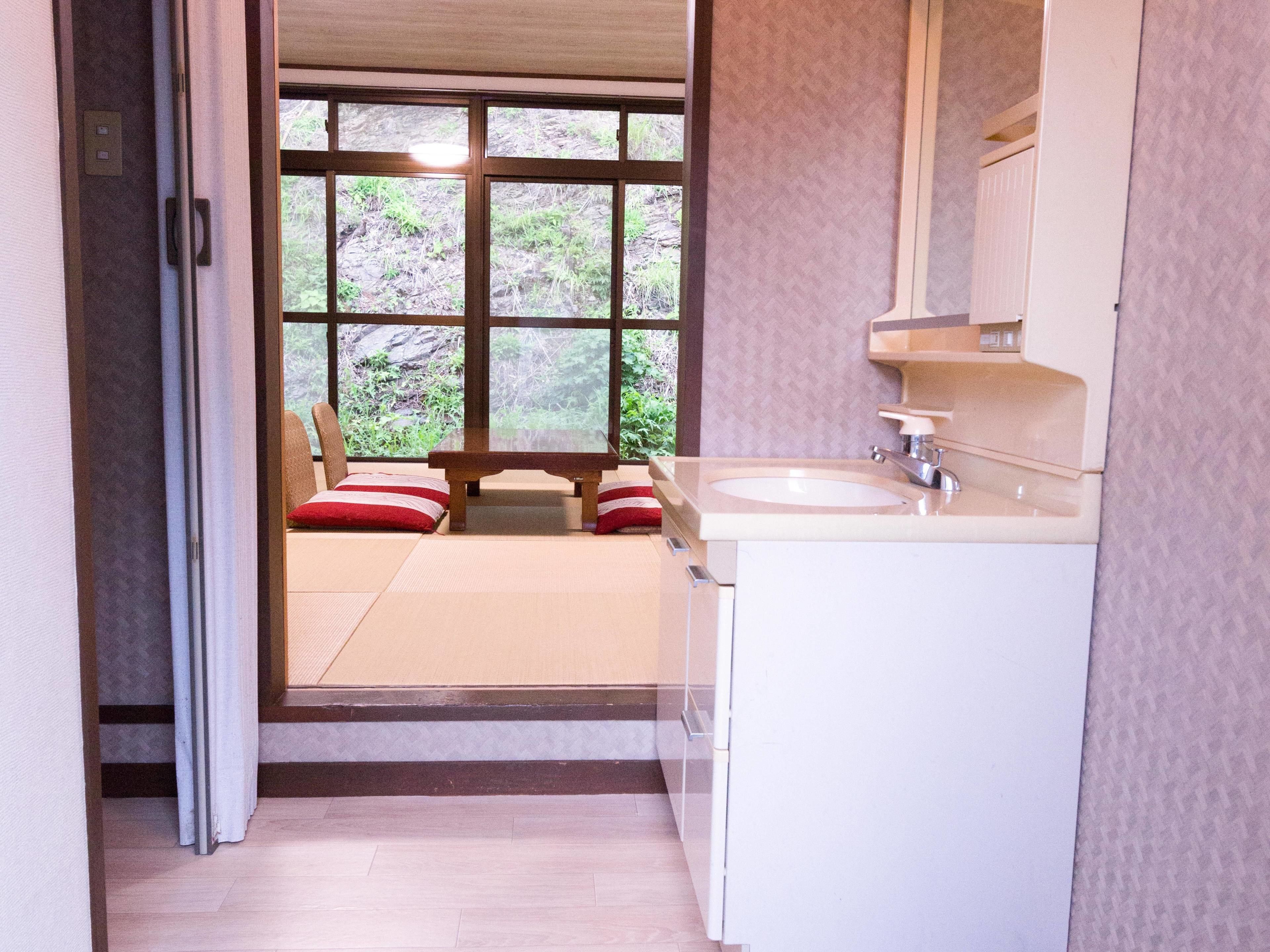 Une salle de bain avec un lavabo, un miroir et une fenêtre.