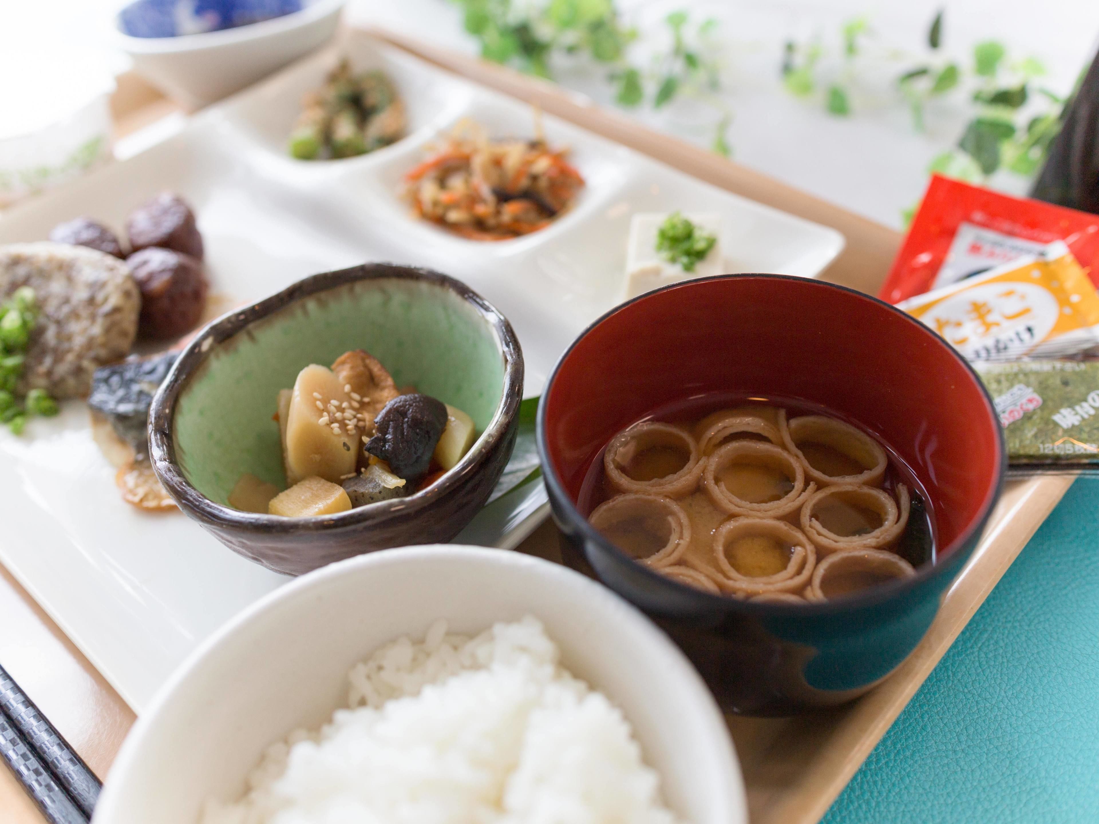 A tray with various dishes including rice, a bowl of soup, and several side dishes.