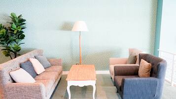 A living room with two sofas, a coffee table, and a floor lamp.