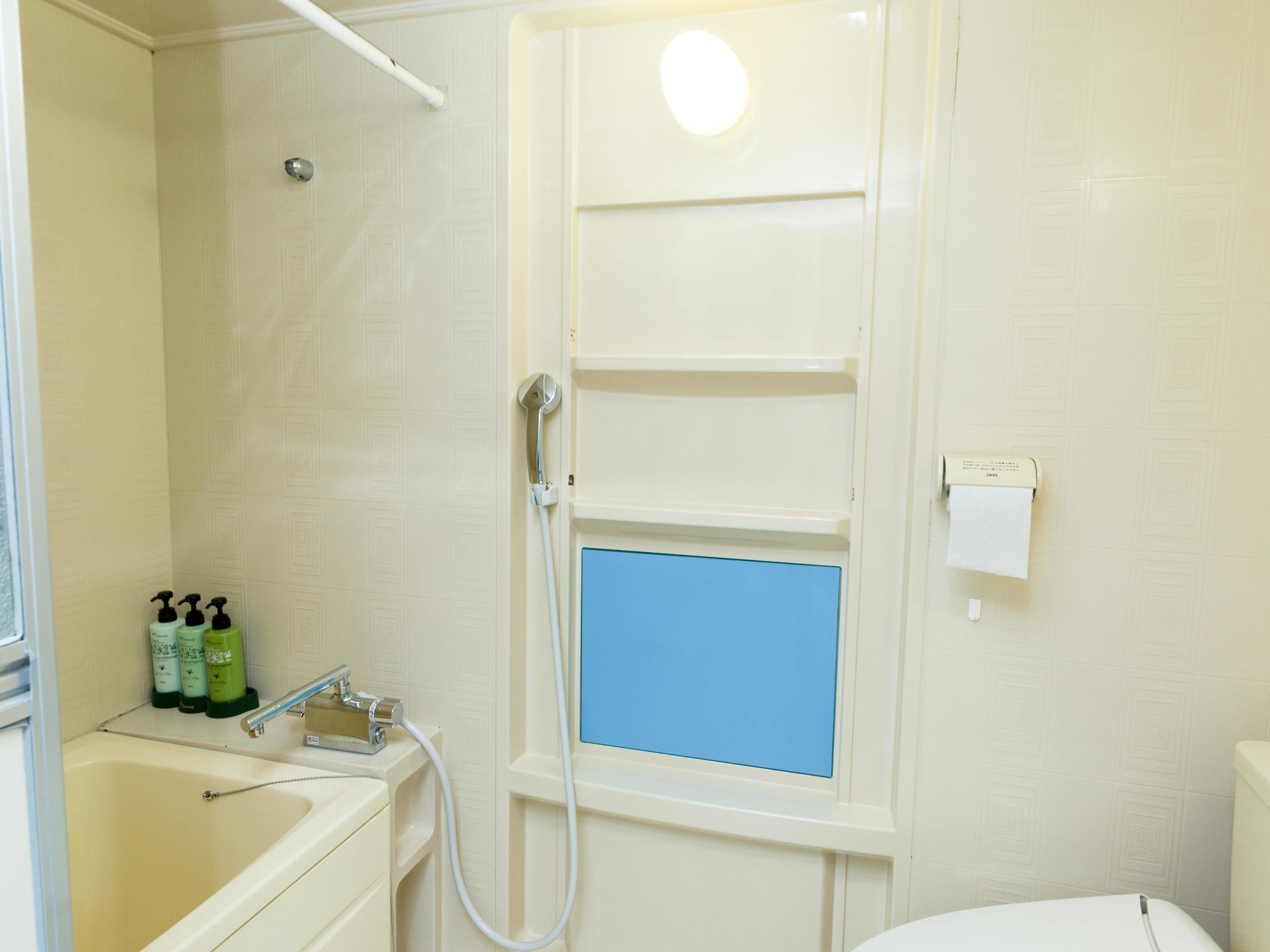 Une salle de bain avec une douche, un lavabo et des toilettes.
