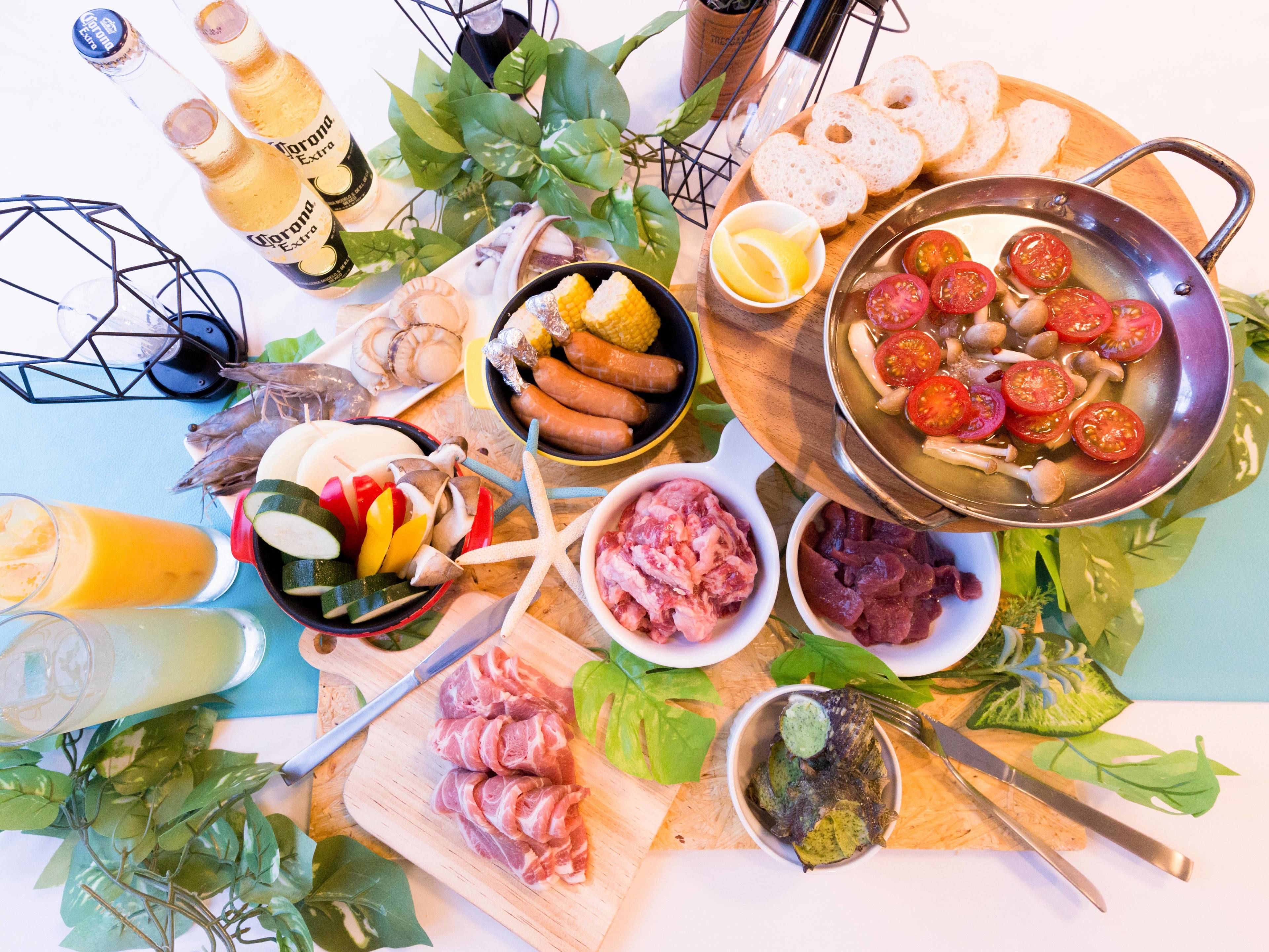 A variety of food items including sausages, tomatoes, and meat on a wooden board.